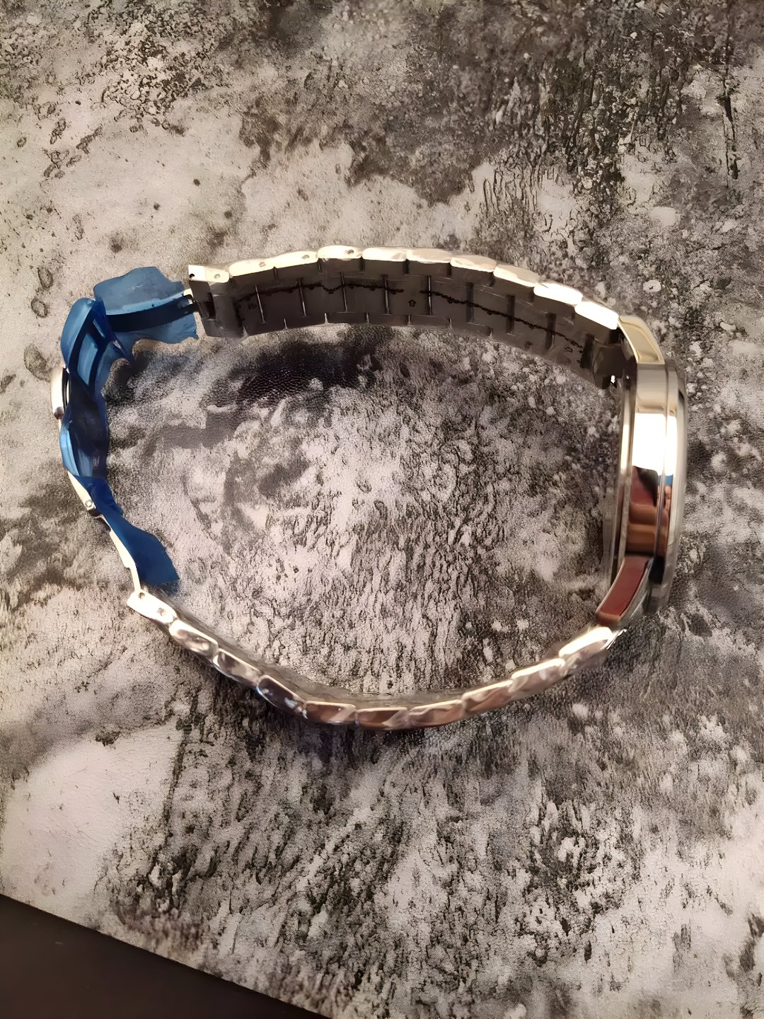 Detail of the Blue Moon stainless steel bracelet resting on grey stone