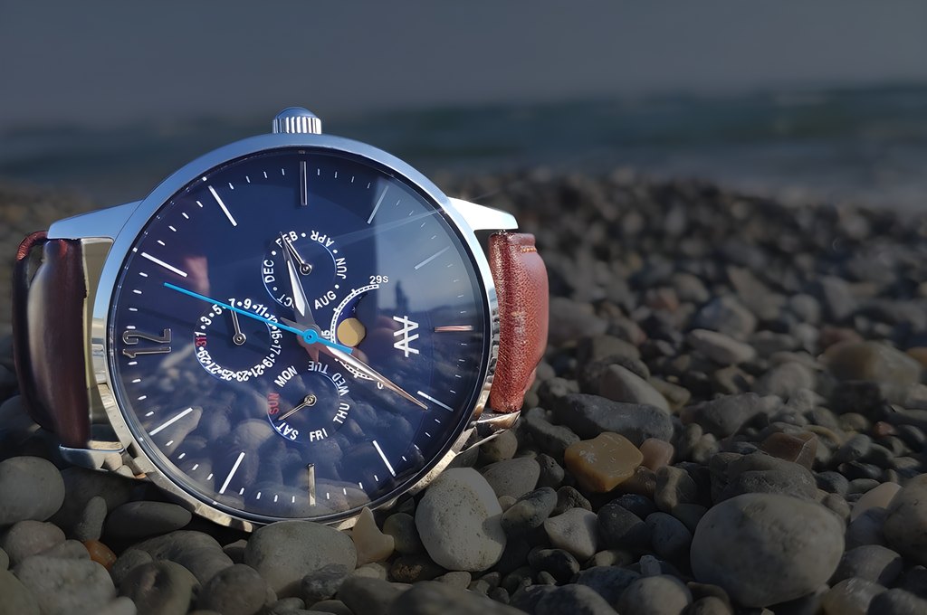 Blue Moon watch on a brown leather strap resting on beach pebbles